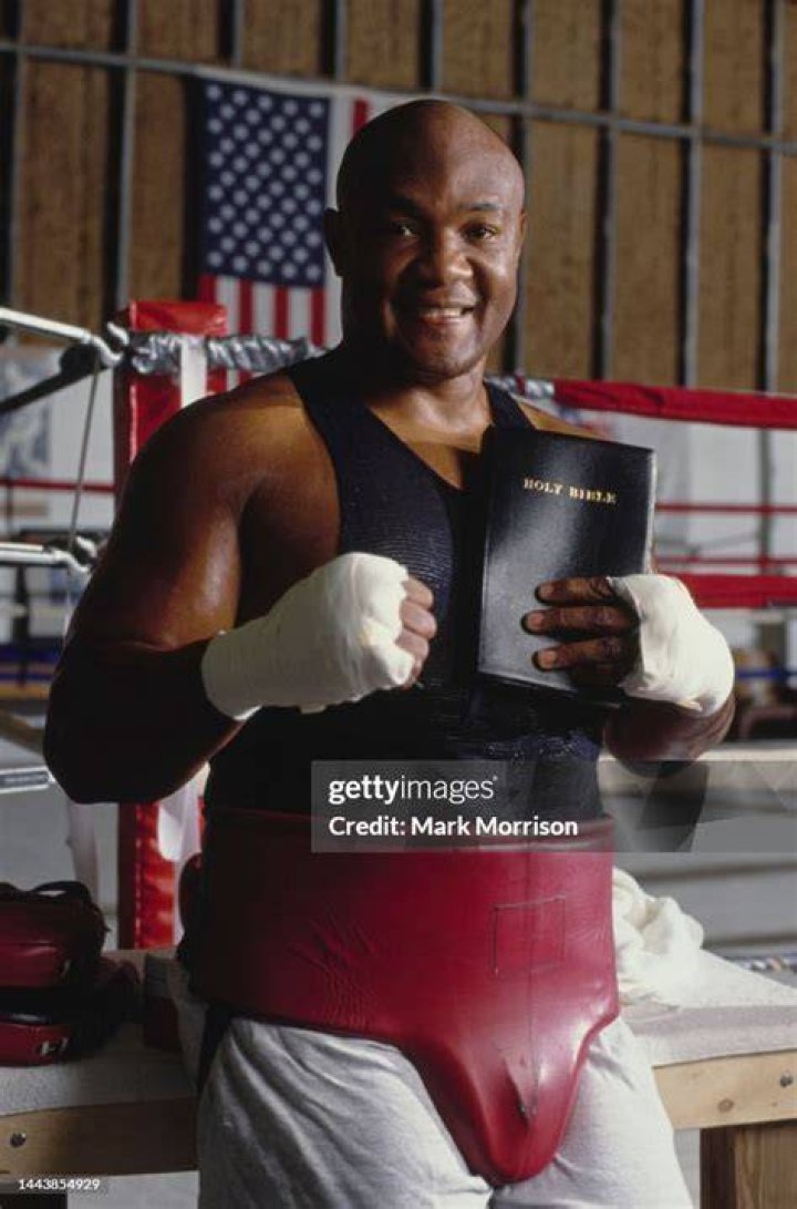 American heavyweight boxer Foreman holding a Bible at his home
